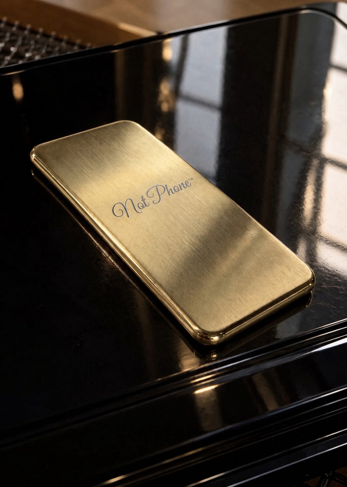 NOT PHONE™ Classic. lying on a black grand piano, mirror-polished edge catching the light