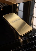 NOT PHONE™ Classic. lying on a black grand piano, mirror-polished edge catching the light